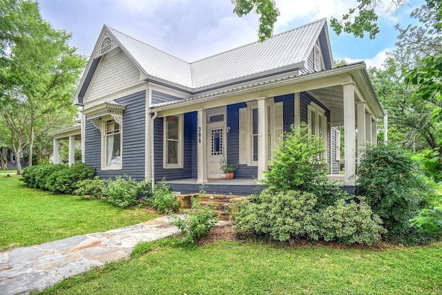 306 5th Ave, Smithville, TX 78957 - view of front of home with a porch, a front lawn, and a metal roof
