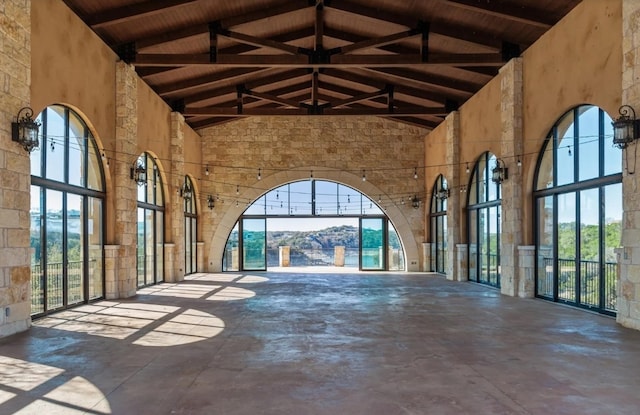 963 Tomichi Trl, Lakeway, TX 78738 - unfurnished living room featuring high vaulted ceiling, unfinished concrete flooring, and a wooden ceiling with exposed beams