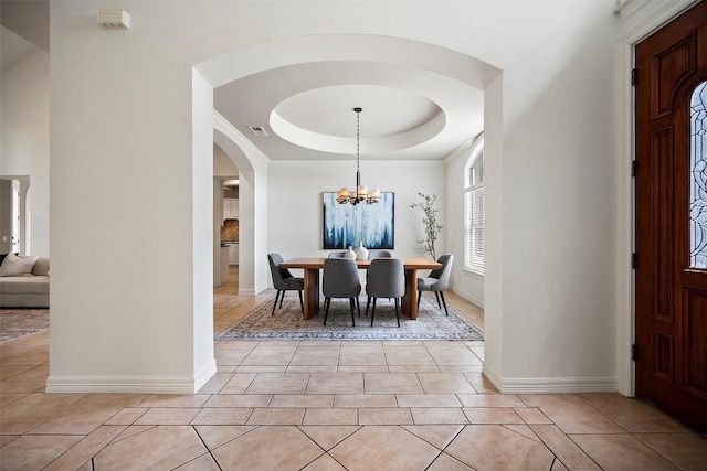 10908 Sans Souci Pl, Austin, TX 78759 - dining area featuring arched walkways, light tile patterned floors, a tray ceiling, and a chandelier
