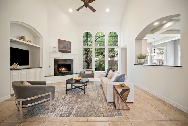 10908 Sans Souci Pl, Austin, TX 78759 - living area with built in shelves, a ceiling fan, a high ceiling, plenty of natural light, and tile patterned floors