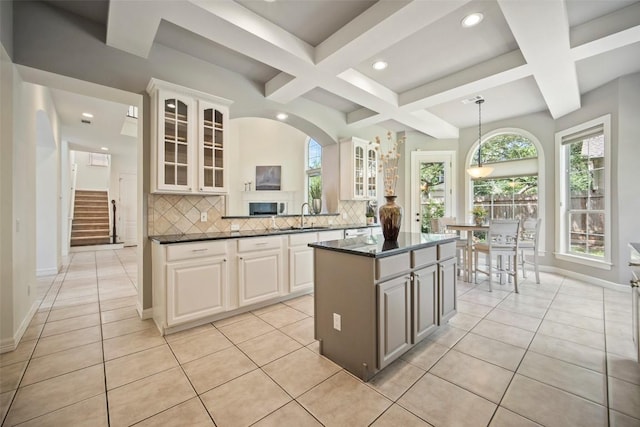 10908 Sans Souci Pl, Austin, TX 78759 - kitchen with coffered ceiling, a center island, tasteful backsplash, glass insert cabinets, and recessed lighting