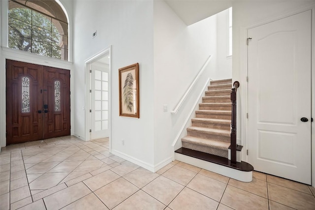 10908 Sans Souci Pl, Austin, TX 78759 - entryway featuring a towering ceiling, stairs, and light tile patterned flooring