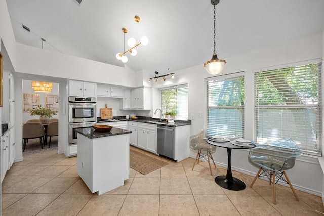 11305 Deputy Dr, Austin, TX 78748 - kitchen with appliances with stainless steel finishes, lofted ceiling, a center island, white cabinets, and light tile patterned flooring
