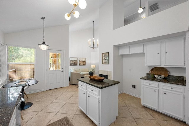 11305 Deputy Dr, Austin, TX 78748 - kitchen featuring a chandelier, high vaulted ceiling, light tile patterned floors, white cabinets, and dark stone counters