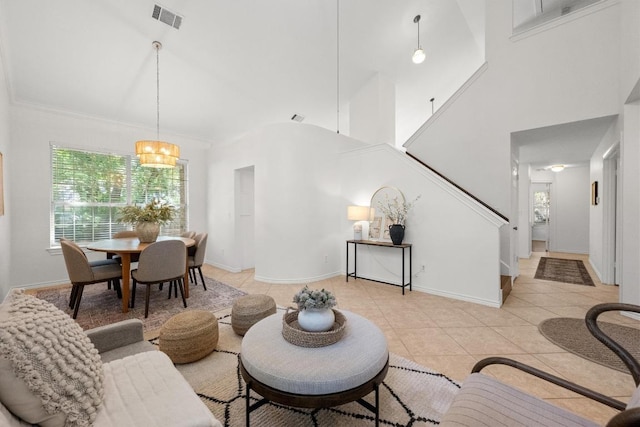 11305 Deputy Dr, Austin, TX 78748 - living area featuring light tile patterned floors, healthy amount of natural light, stairway, a towering ceiling, and a chandelier
