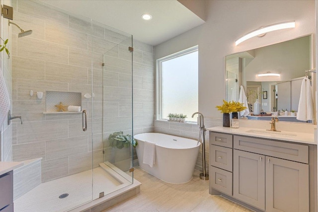 280 Whitney Run, Buda, TX 78610 - bathroom with a shower stall, vanity, a freestanding bath, tile walls, and recessed lighting