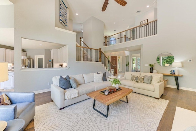 280 Whitney Run, Buda, TX 78610 - living room with wood finished floors, stairs, ceiling fan, a towering ceiling, and recessed lighting