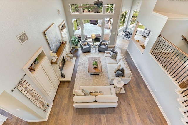 280 Whitney Run, Buda, TX 78610 - living area featuring a high ceiling, wood finished floors, healthy amount of natural light, and stairs