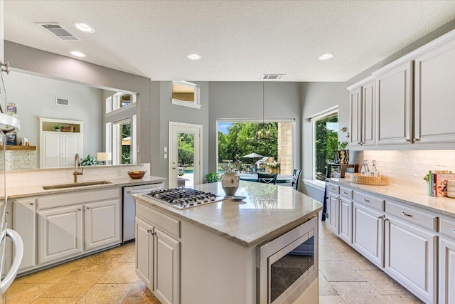 280 Whitney Run, Buda, TX 78610 - kitchen with appliances with stainless steel finishes, stone tile floors, decorative backsplash, recessed lighting, and a kitchen island