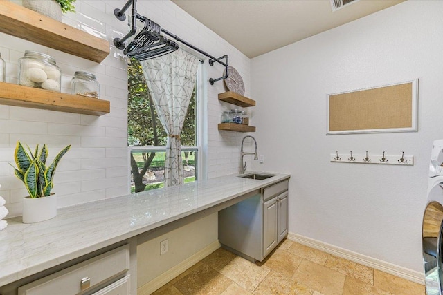 280 Whitney Run, Buda, TX 78610 - kitchen featuring open shelves, backsplash, built in study area, and light stone countertops