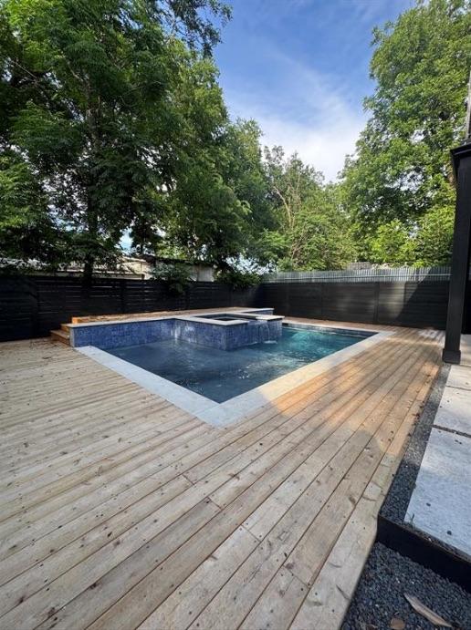 3402 Goodwin Ave Unit 1, Austin, TX 78702 - view of swimming pool featuring a wooden deck, a fenced backyard, and a pool with connected hot tub