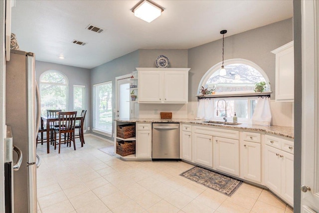 8500 E Potosi Cv, Austin, TX 78717 - kitchen with stainless steel appliances, white cabinetry, and light stone counters