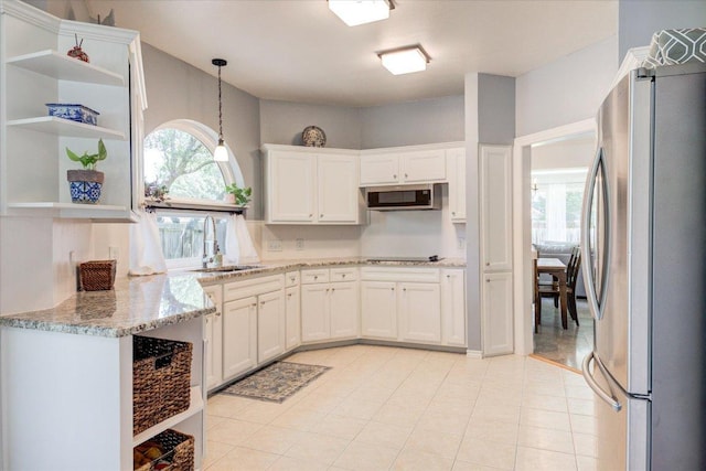 8500 E Potosi Cv, Austin, TX 78717 - kitchen with stainless steel appliances, white cabinetry, light stone counters, open shelves, and pendant lighting