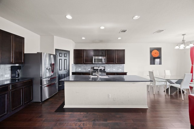 12000 Kincardine Way, Austin, TX 78754 - kitchen with stainless steel appliances, dark countertops, a chandelier, tasteful backsplash, and dark brown cabinets