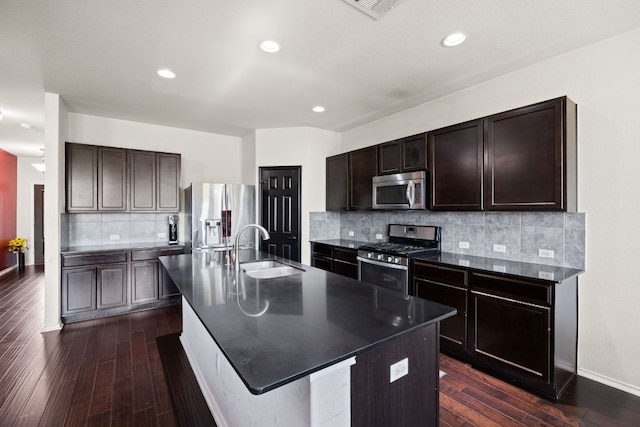 12000 Kincardine Way, Austin, TX 78754 - kitchen featuring stainless steel appliances, dark countertops, dark wood finished floors, dark brown cabinetry, and tasteful backsplash