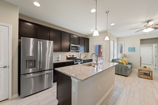 8713 Alderman Dr, Austin, TX 78747 - kitchen with stainless steel appliances, dark brown cabinets, light stone countertops, a ceiling fan, and decorative backsplash