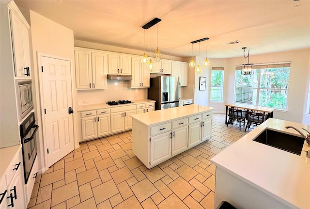 12504 Gun Metal Dr, Austin, TX 78739 - kitchen with black appliances, a kitchen island, light countertops, white cabinetry, and decorative light fixtures