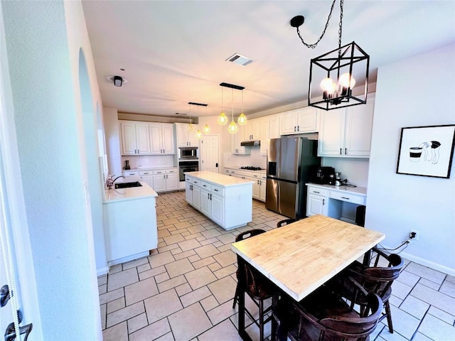 12504 Gun Metal Dr, Austin, TX 78739 - kitchen featuring stainless steel appliances, white cabinetry, light countertops, a chandelier, and a kitchen island