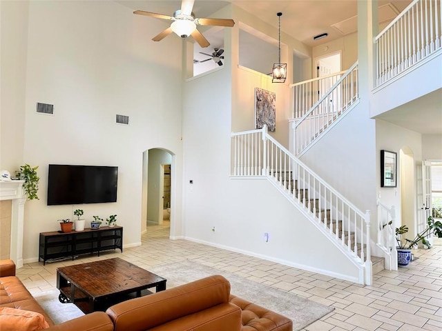 12504 Gun Metal Dr, Austin, TX 78739 - living area with arched walkways, a towering ceiling, ceiling fan, and stairs