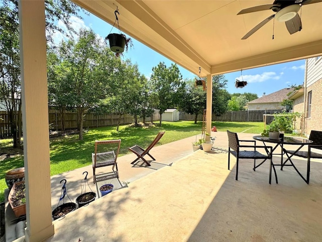 12504 Gun Metal Dr, Austin, TX 78739 - fenced backyard featuring a storage unit, a patio area, a ceiling fan, and outdoor dining space
