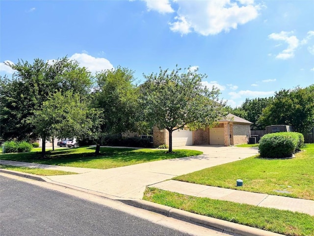 12504 Gun Metal Dr, Austin, TX 78739 - view of property hidden behind natural elements featuring a front yard, concrete driveway, a garage, and brick siding