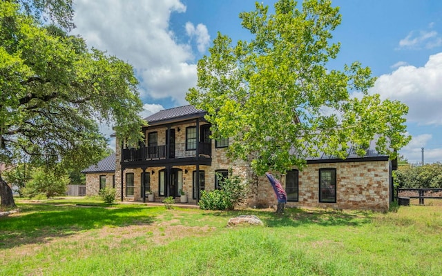 4204 Deer Tract St, Round Rock, TX 78681 - view of front facade featuring a standing seam roof, a balcony, a metal roof, and stone siding