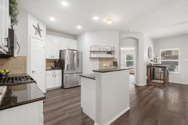 3713 Eagle Fledge Ter, Pflugerville, TX 78660 - kitchen with appliances with stainless steel finishes, dark countertops, open shelves, dark wood-type flooring, and arched walkways