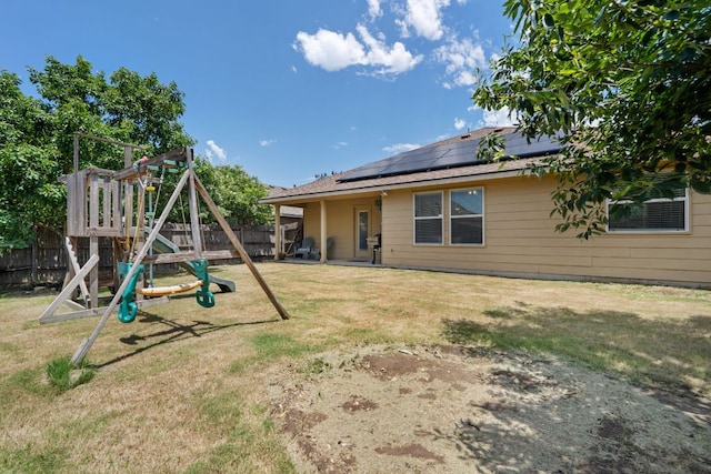 3713 Eagle Fledge Ter, Pflugerville, TX 78660 - back of property featuring a playground, a fenced backyard, and solar panels