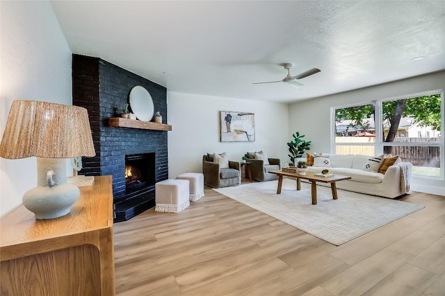 2402 Broken Oak Dr, Austin, TX 78745 - living area with ceiling fan, a brick fireplace, and light wood finished floors