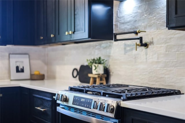 2402 Broken Oak Dr, Austin, TX 78745 - kitchen with stainless steel gas range, backsplash, blue cabinets, and light countertops