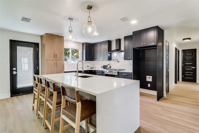 2402 Broken Oak Dr, Austin, TX 78745 - kitchen with wall chimney exhaust hood, light wood-type flooring, light countertops, backsplash, and a kitchen bar