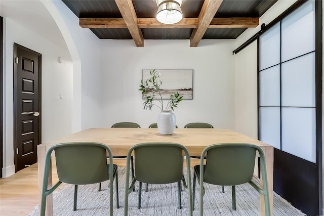2402 Broken Oak Dr, Austin, TX 78745 - dining area featuring arched walkways, wood finished floors, and a wooden ceiling with exposed beams