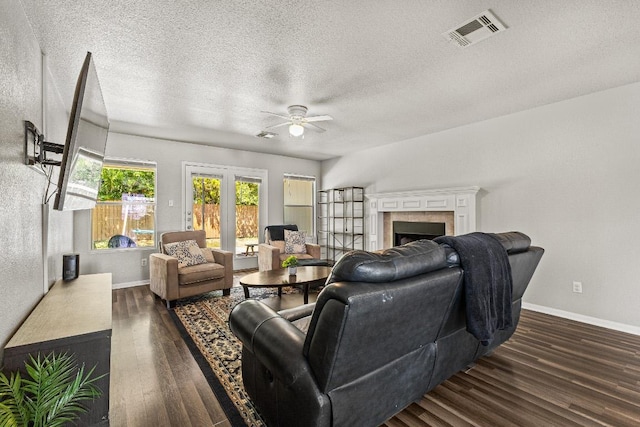 5302 Oster Dr, Killeen, TX 76542 - living room with ceiling fan, dark wood finished floors, a tile fireplace, a textured ceiling, and french doors