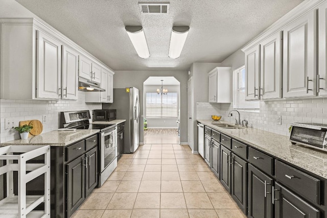 5302 Oster Dr, Killeen, TX 76542 - kitchen with appliances with stainless steel finishes, under cabinet range hood, white cabinetry, a textured ceiling, and a chandelier