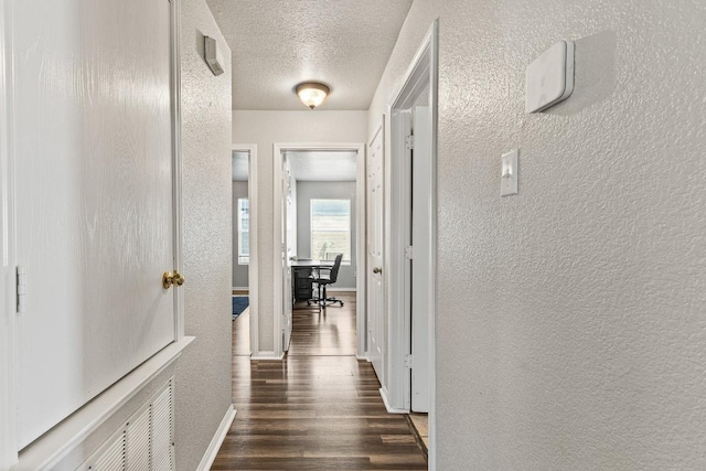 5302 Oster Dr, Killeen, TX 76542 - hall featuring a textured wall, dark wood finished floors, a textured ceiling, and a desk