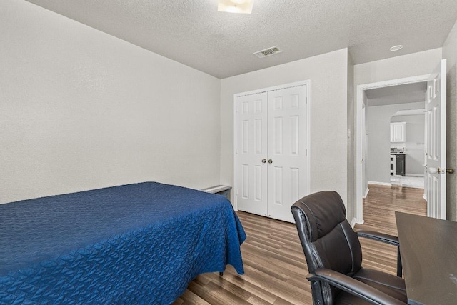 5302 Oster Dr, Killeen, TX 76542 - bedroom featuring wood finished floors, a textured ceiling, an office area, and a closet
