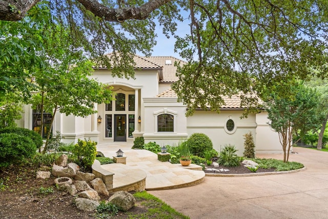 8634 Navidad Dr, Austin, TX 78735 - mediterranean / spanish house featuring a tile roof, stucco siding, and driveway