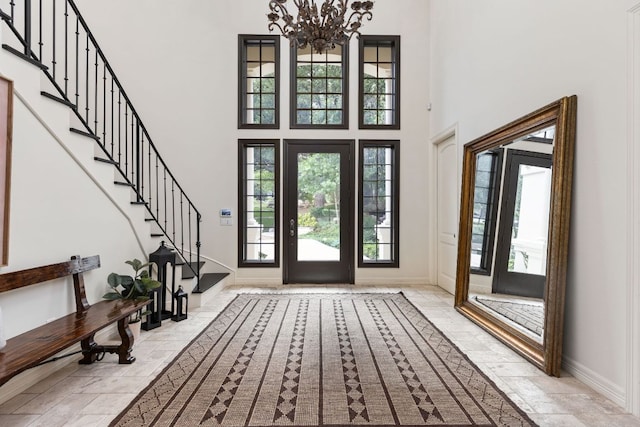 8634 Navidad Dr, Austin, TX 78735 - entryway featuring a towering ceiling, plenty of natural light, a chandelier, stairs, and stone tile floors