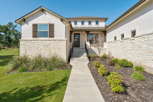 230 Wilderness Cv, Driftwood, TX 78619 - view of front facade featuring stone siding, a porch, stucco siding, and a front lawn