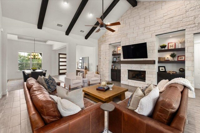 230 Wilderness Cv, Driftwood, TX 78619 - living area with a ceiling fan, a fireplace, a chandelier, and wood finished floors