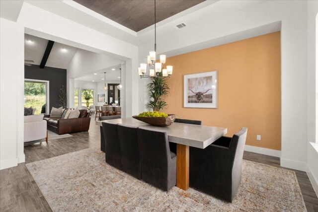 230 Wilderness Cv, Driftwood, TX 78619 - dining space with wood finished floors, a chandelier, a raised ceiling, and recessed lighting
