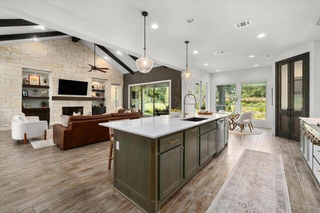 230 Wilderness Cv, Driftwood, TX 78619 - kitchen featuring light countertops, a fireplace, wood finished floors, stainless steel dishwasher, and recessed lighting