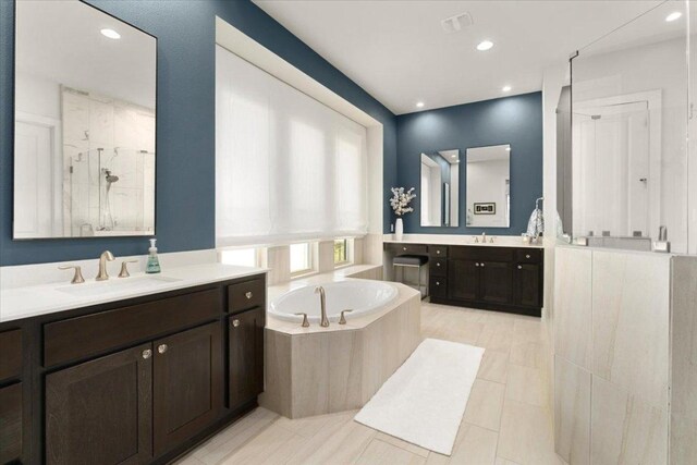 230 Wilderness Cv, Driftwood, TX 78619 - full bathroom featuring two vanities, a bath, a stall shower, recessed lighting, and tile patterned flooring