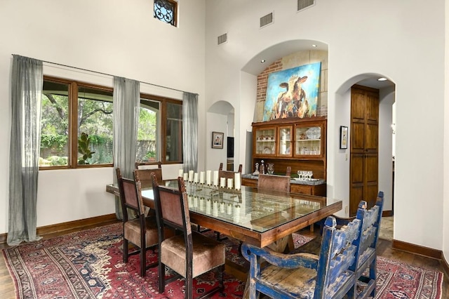 3816 Pappys Way, Austin, TX 78730 - dining room with a high ceiling, arched walkways, and wood finished floors