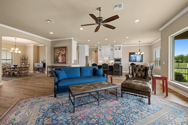 108 Marbella Way, Georgetown, TX 78633 - living room with a chandelier, arched walkways, light wood finished floors, a ceiling fan, and recessed lighting