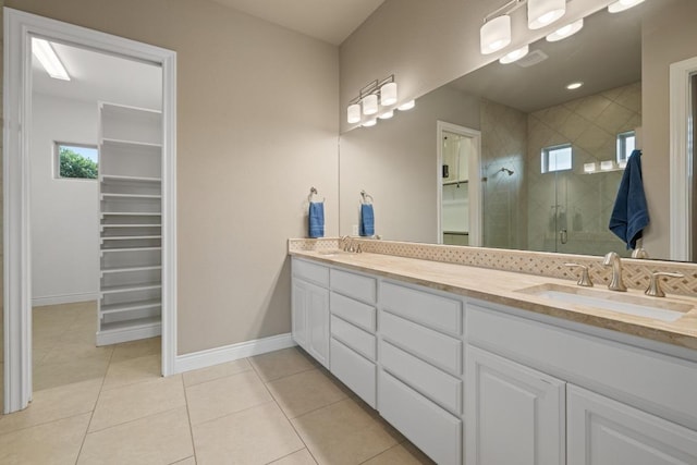 108 Marbella Way, Georgetown, TX 78633 - full bath with double vanity, a shower stall, tile patterned floors, a walk in closet, and healthy amount of natural light