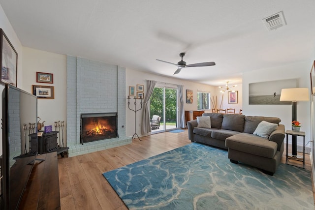 2801 Cornish Cir, Austin, TX 78745 - living area with wood finished floors, ceiling fan, a brick fireplace, and a chandelier