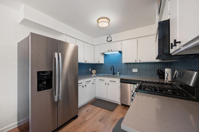 2801 Cornish Cir, Austin, TX 78745 - kitchen with appliances with stainless steel finishes, light wood-style flooring, tasteful backsplash, and white cabinetry
