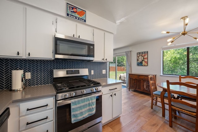 2801 Cornish Cir, Austin, TX 78745 - kitchen featuring appliances with stainless steel finishes, a chandelier, backsplash, and white cabinets