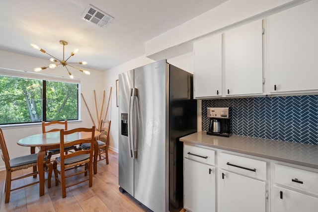 2801 Cornish Cir, Austin, TX 78745 - kitchen with stainless steel refrigerator with ice dispenser, decorative backsplash, a chandelier, white cabinetry, and light wood-style flooring